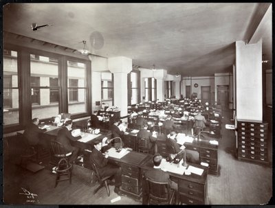 Hommes et une femme travaillant à des bureaux dans un bureau de la Metropolitan Life Insurance Co. à la 23ème Rue et Madison Avenue, New York, 1907 - Byron Company